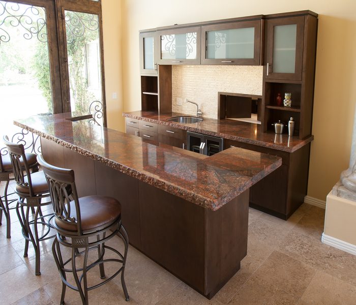 transitional style kitchen bar in dark wood stain with dark stone quartz countertops