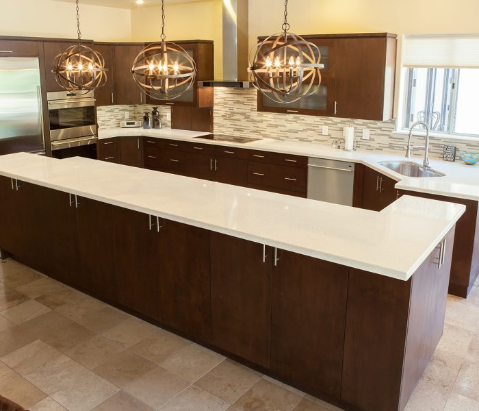 modern style kitchen in dark wood stain with white quartz countertops and modern backsplash