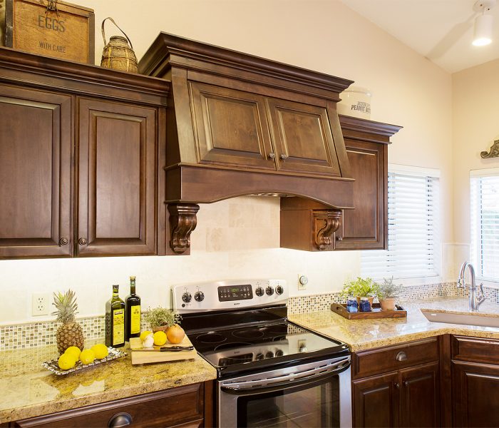 transitional style kitchen in dark wood stain with natural stone quartz countertops