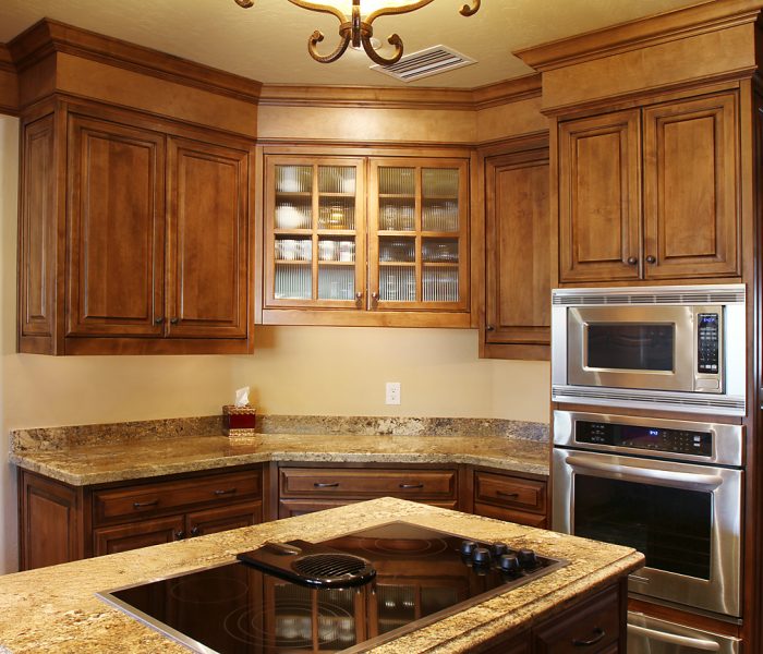 transitional style kitchen in dark wood stain with natural stone quartz countertops
